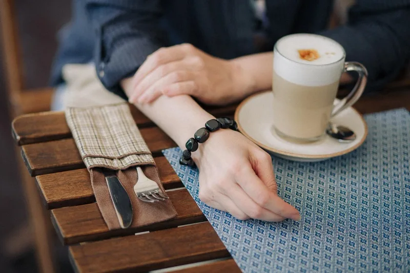Zwei Kaffeetassen auf einem Holztisch in einer entspannten Café-Umgebung.