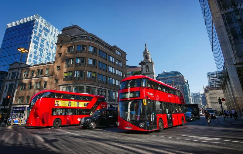 Ein roter Doppeldeckerbus überquert eine belebte Kreuzung im Zentrum von London.