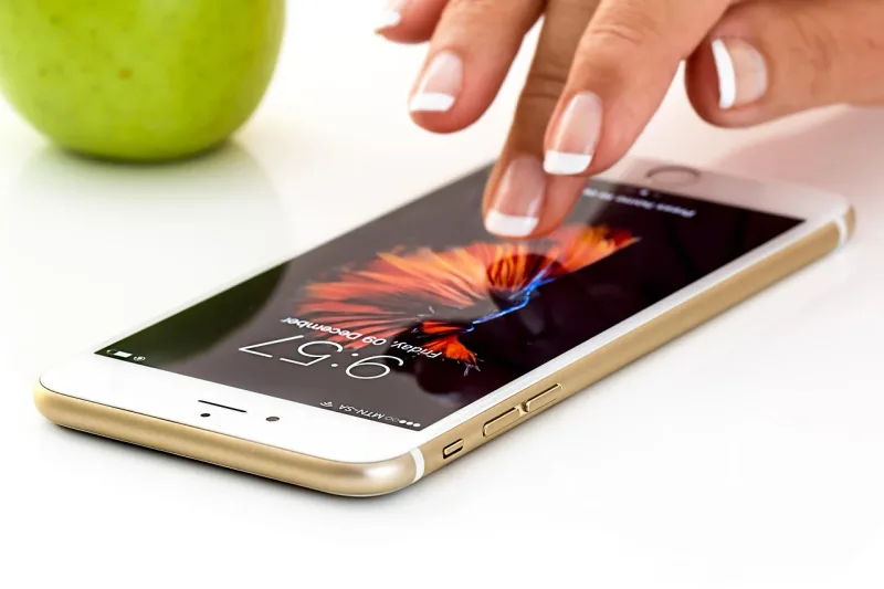 Eine Hand hält ein Smartphone mit aktivem Bildschirm. Das Bild symbolisiert digitale Kommunikation und die Nutzung von Apps.