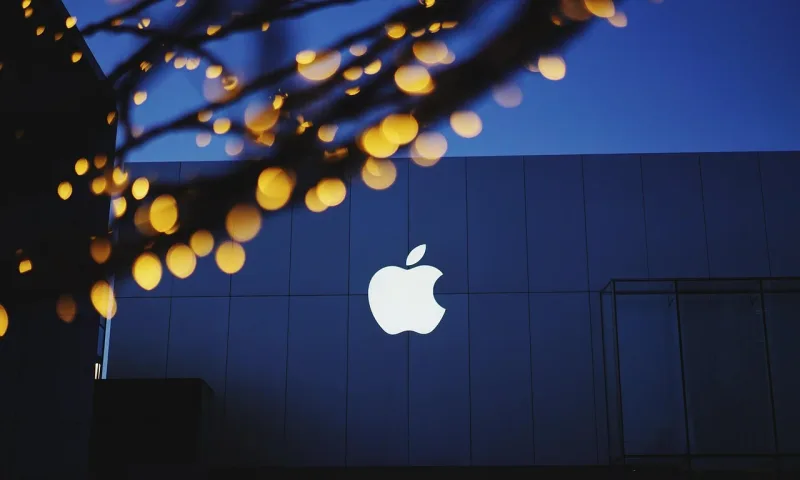 Ein stilisiertes Apple-Logo mit blauen Bokeh-Lichtern und einem unscharfen Gebäude im Hintergrund.