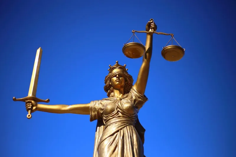 Eine Statue der Justitia, der römischen Göttin der Gerechtigkeit, mit verbundenen Augen, Waage und Schwert.